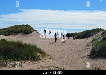 Personnes marchant sur les dunes de sable de Ynys Llanddwyn, plage de Llanddwyn, pays de Galles, Royaume-Uni Banque D'Images