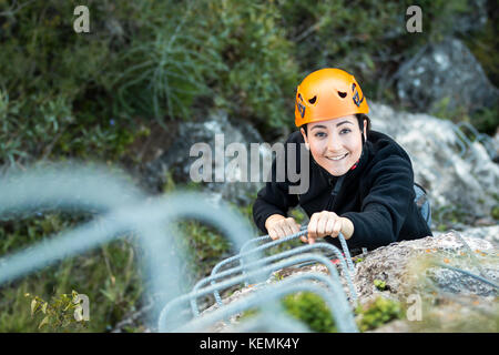 Au-dessus de pretty smiling woman'grimper sur la montagne et looking at camera Banque D'Images