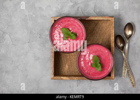 Petits fruits rouges smoothies en verres sur un fond de béton gris. Vue de dessus. copy space Banque D'Images