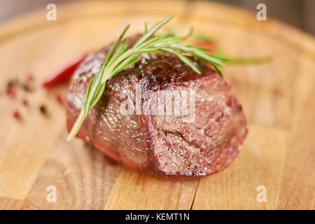 Délicieux steak de boeuf sur assiette en bois. boeuf grillé steak au romarin sur planche de bois. Banque D'Images