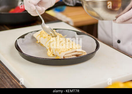 Chef putting fromage sur burrito. chef de cuisine mexicaine préparation à burrito burrito. Dans une poêle. Banque D'Images