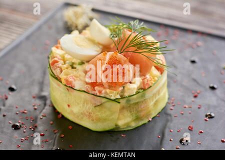 Salade de saumon et Olivier avec tobiko. délicieux caviar servi avec salade olivier tobiko saumon, caviar, l'aneth et œufs. salade appétissante dans un restaurant. Banque D'Images