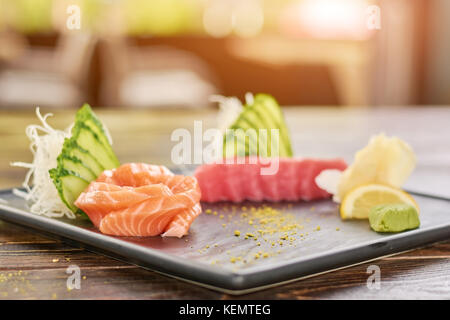 Poisson frais sashimi saumon cru. et le thon sashimi servi avec du saumon, concombre et wasabi. Banque D'Images