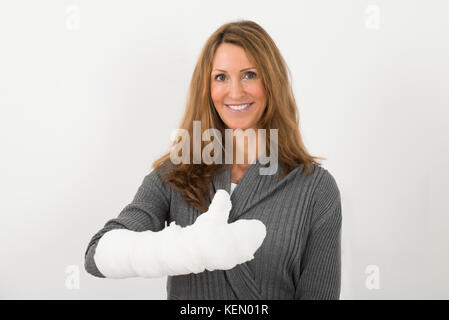 Portrait of happy young woman avec fracture de la main à bandage Banque D'Images