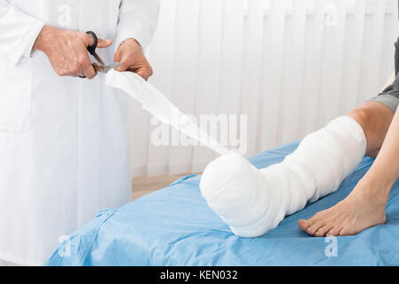 Close-up de bandage de jambe médecin patient lying on bed in hospital Banque D'Images