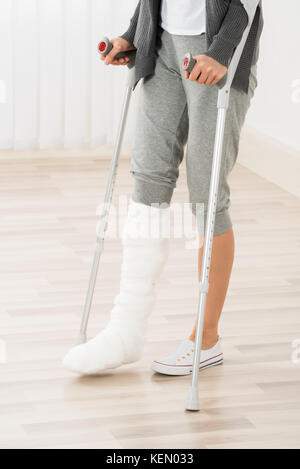 Close-up of woman jambe en plâtre avec des béquilles en marchant Banque D'Images