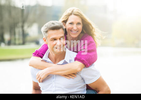 Portrait Of Happy Man Piggybacking son épouse Banque D'Images