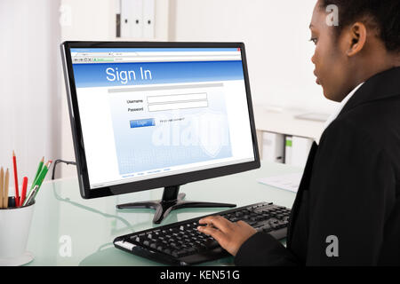 Close-up of young African businesswoman signature en site sur ordinateur Banque D'Images