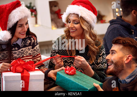 Cheerful friends échange présente à la veille de Noël Banque D'Images