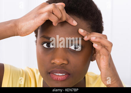 Portrait de jeune femme africaine à la recherche de bouton sur le front Banque D'Images