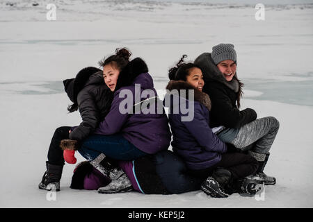 Inukjuak, Nunavik, Québec, Canada. 31 mars 2017. Jeunes filles inuites jouant autour et attendant l'arrivée des chiens traîneaux. Depuis 2001, Ivakkak est un événement qui honore les chiens Husky, tous les deux ans, la course traverse plusieurs villages du Nunavik. Les chiens Husky ont une longue tradition de vivre en étroite collaboration avec l'homme. Au siècle dernier, ils aidaient en tant que gardiens indispensables contre les prédateurs, et en l'absence de GPS, ils pouvaient très facilement trouver leur chemin dans la toundra. Crédit : Yves Choquette/SOPA/ZUMA Wire/Alamy Live News Banque D'Images