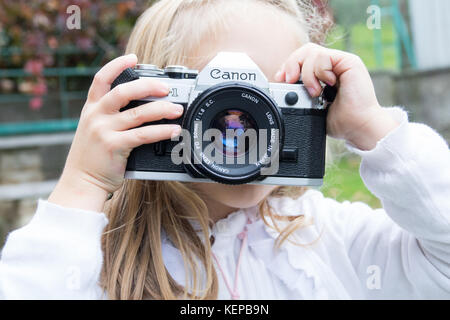 Trieste, Italie - 22 octobre 2017 : appareil photo Canon ae-1 35mm ,petite fille de prendre des photos à l'aide de caméra film vintage Banque D'Images