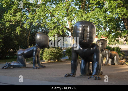 Trois gros bébé bronze sculptures de l'artiste tchèque David Černý dans un parc sur l'île Kampa, à Prague, en République tchèque, à l'été. Banque D'Images