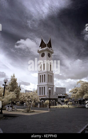 Une photographie capturant le monument JAM Gadang sous un ciel nuageux, situé à Bukittinggi, Indonésie, connu pour sa tour de l'horloge emblématique et son importance culturelle. Banque D'Images