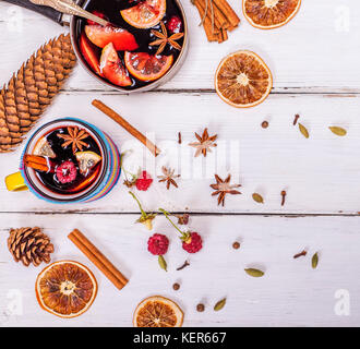 Vin chaud dans une tasse et ingrédients pour faire un verre sur un fond de bois blanc, vue du dessus Banque D'Images