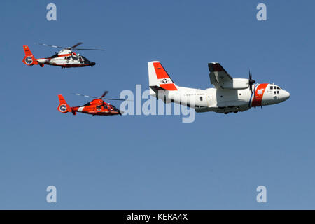 Une paire de MH-65 de la Garde côtière canadienne d'hélicoptères Dauphin Air Station San Francisco voler en formation serrée avec un C-27J Spartan d'Air Station Sacramento Banque D'Images