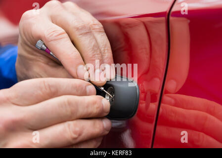 Close-up of hand holding personne lockpicker pour ouvrir la porte de voiture Banque D'Images