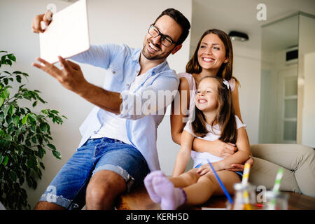 Famille heureuse de prendre dans leur maison selfies Banque D'Images