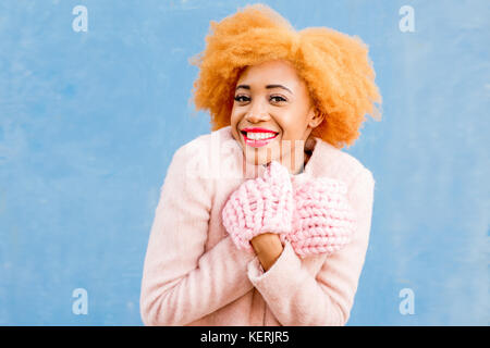 Portrait d'une femme dans des vêtements d'hiver sur le fond bleu Banque D'Images