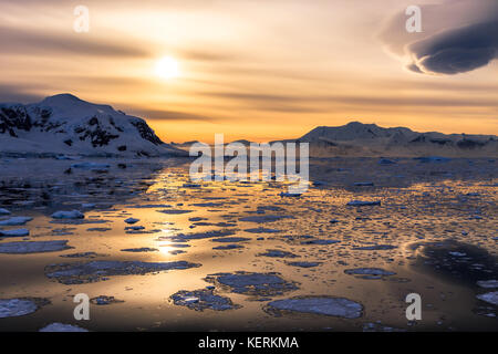 Coucher de soleil sur les montagnes de glaciers et icebergs à la dérive du détroit de Lemaire, de l'Antarctique Banque D'Images