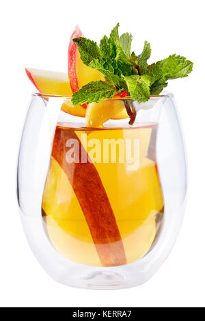 Vin chaud dans un verre décoré avec des tranches de pomme et de feuilles de menthe avec un bâton de cannelle sur un fond blanc. isolés. Banque D'Images