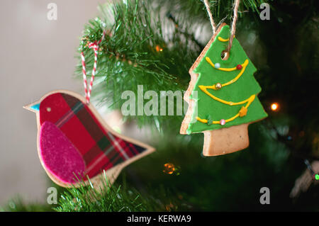 Un témoin sous la forme d'un arbre de Noël et un oiseau rose et textiles sont accrochés sur une branche de l'arbre de Noël. focus sélectif, zone de flou. Banque D'Images