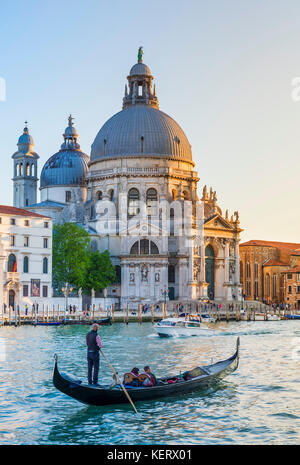 Venise ITALIE VENISE Gondolier de touristes en gondole Venise Italie près de la basilique Santa Maria della Salute grand canal Venise Italie Europe de l'UE Banque D'Images