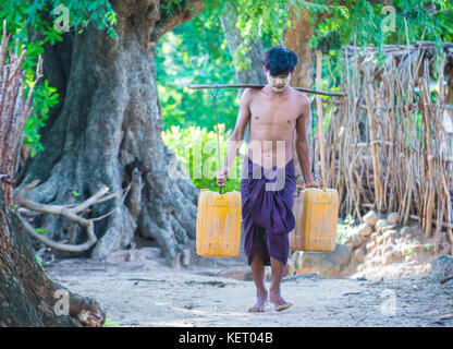 Fermier birman transportant des seaux remplis d'eau dans un village près de Bagan Banque D'Images