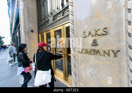 Les gens sont en marche le vaisseau amiral Saks Fifth Avenue magasin sur la Cinquième Avenue à New York. Banque D'Images