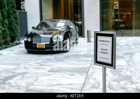 Avis près de l'entrée du parc résidentiel de l'avenue chic 432 tower à New York avec un noir parqué Bentley. Banque D'Images