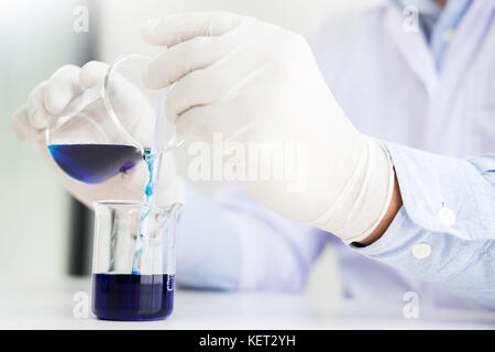 Les scientifiques et le matériel scientifique, verser le mélange liqiud réactifs de laboratoire chimie,bécher recherche concept Banque D'Images