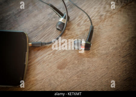Smartphone avec le casque sur un vieux fond de bois,vintage,ton soft focus Banque D'Images