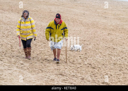 Marcheurs pour chiens - un couple marchant leur chien sur Fistral Beach Newquay. Banque D'Images