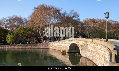 Hangzhou, Chine - 5 décembre 2014 : West Lake, célèbre parc dans la ville de Hangzhou. Les gens ordinaires marchent sur un pont de pierre Banque D'Images