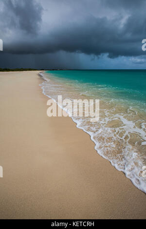 Les nuages de tempête sur du sable fin encadré par les eaux turquoise de la plage de sable rose Antigua-et-Barbuda Antilles îles sous le vent Banque D'Images