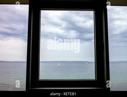 Vue sur mer et bateaux à voile à travers la vitre à l'hôtel Helnan Marselis,Danemark Banque D'Images