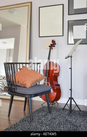 Violoncelle ou violoncelle instrument de musique avec chaise en bois et un oreiller à la maison Banque D'Images