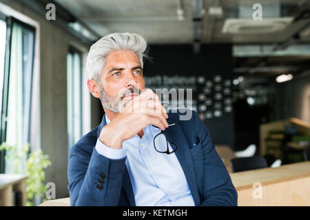 Mature businessman en costume bleu dans le bureau. Banque D'Images