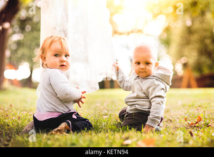 Deux bébés sur l'herbe dans le jardin. Banque D'Images