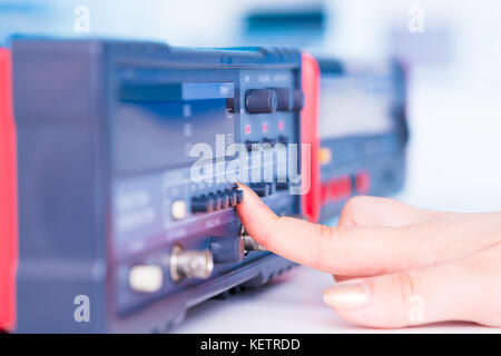 Femme appuie sur un bouton sur un instrument de mesure électronique Banque D'Images