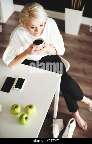 Femme avec du café à la maison de repos après le travail Banque D'Images