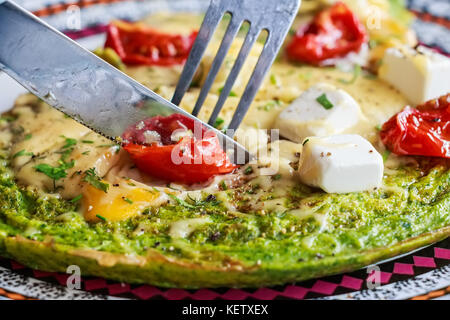 Omelette aux épinards avec des tomates et du fromage sur le dessus Banque D'Images