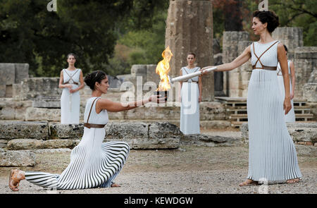 Olympia, Grèce. 24 octobre 2017. L'actrice grecque Katerina Lehou (R)allume la torche olympique à Olympie, Grèce, le 24 octobre 2017. La ville sud-coréenne de Pyeongchang accueille les Jeux olympiques d'hiver de 2018. Crédit : Alkis Konstantinidis/POOL/dpa/Alamy Live News Banque D'Images