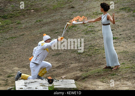 Olympia, Grèce. 24 octobre 2017. L'actrice grecque Katerina Lehou (R)allume la torche olympique à Olympie, Grèce, le 24 octobre 2017. La ville sud-coréenne de Pyeongchang accueille les Jeux olympiques d'hiver de 2018. Crédit : Angelos Tzortzinis/dpa/Alamy Live News Banque D'Images