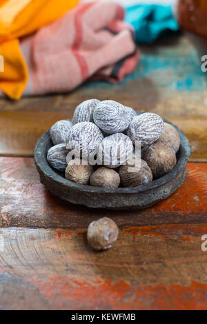 D'ÉPICES d'hiver savoureux, muscade entière séchée utilisée comme ingrédient dans de nombreux plats, lait de poule, vin chaud, Close up sur la vieille table en bois close up Banque D'Images