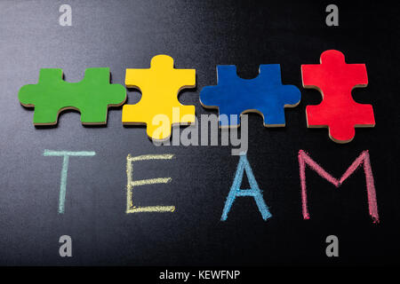 Puzzle coloré Jigsaw avec équipe de texte sur Blackboard Banque D'Images