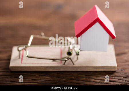 Close-up of a House Model On Mousetrap au bureau en bois Banque D'Images