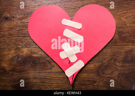 High Angle View Of A Broken Heart fixe avec bandage sur un bureau en bois Banque D'Images