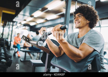 Young handsome man doing exercises in gym Banque D'Images