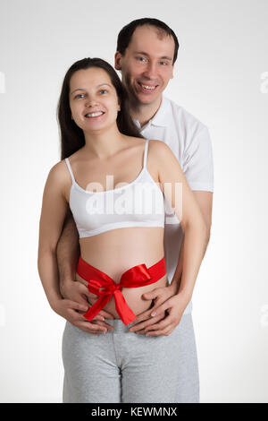 Magnifique portrait de femme enceinte avec mari sur fond blanc Banque D'Images